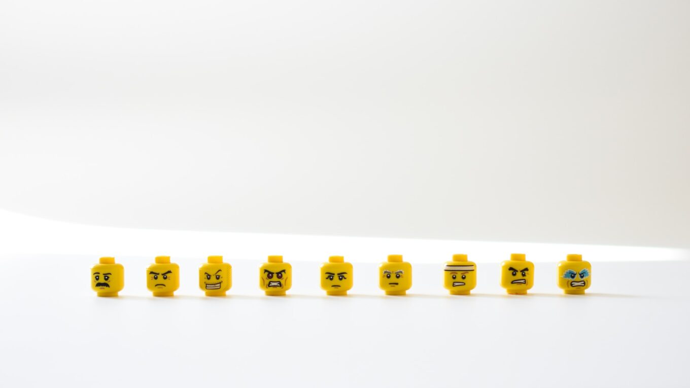 Row of Lego minifig heads, different facial expressions from happy to sad, angry to confused